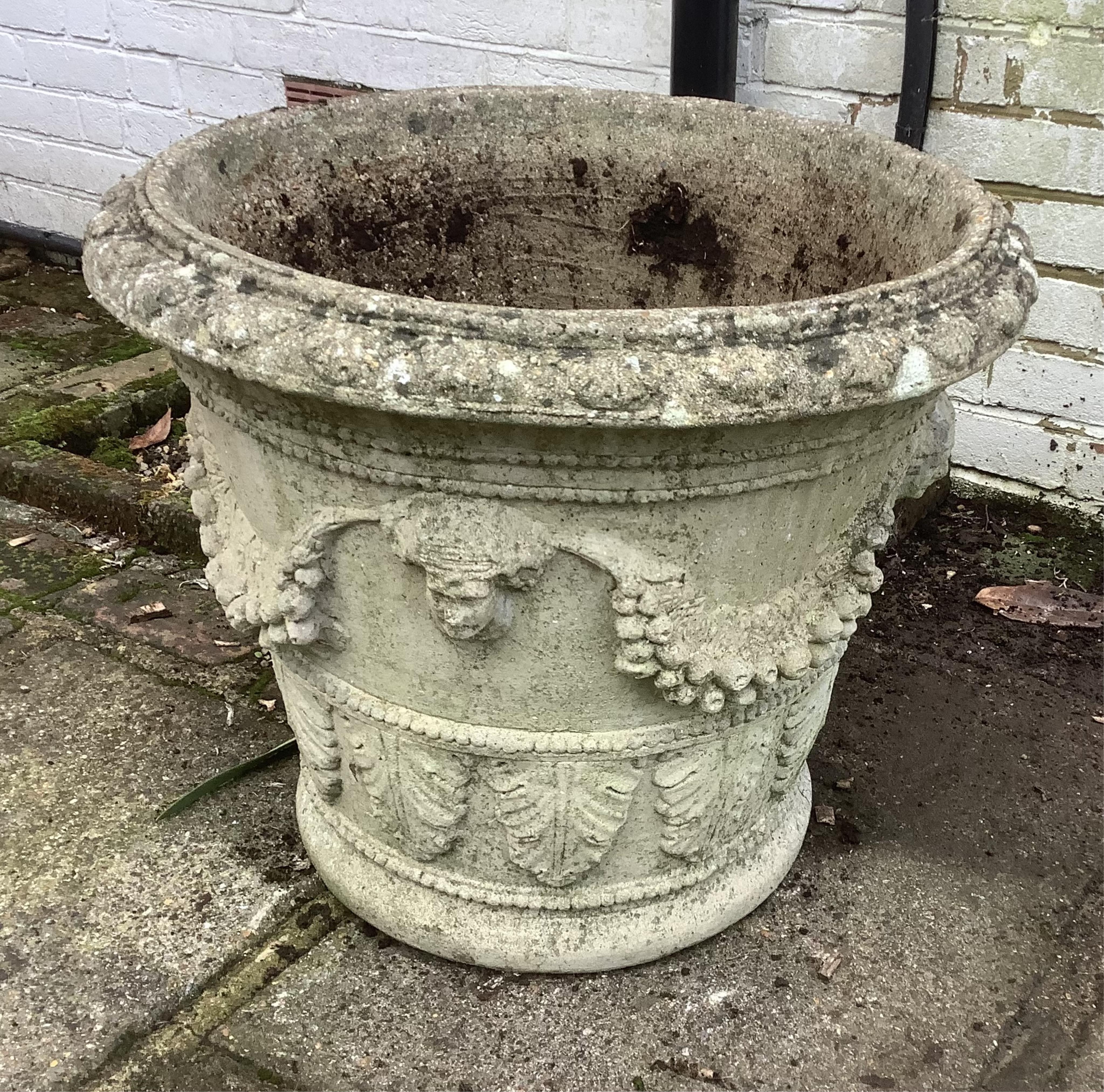 A pair of circular reconstituted stone garden urns, height 50cm, depth 60cm. planting removed. Condition - weathered otherwise good